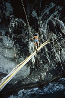 Collecting Prints: Sea gipsy on a bamboo bridge going to collect birds