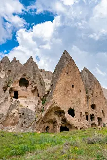 Cappadocia Prints: Selime ancient town features houses carved into rocks in Cappadocia Turkey during a sunny day with clouds