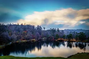 Photographer Prints: Serene lake with reflection of autumn trees under a dynamic blue sky with clouds at dusk in the Lake District