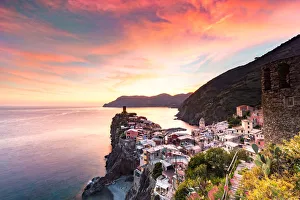 Liguria Prints: The setting sun lights up the sky and casts an orange glow over the old town