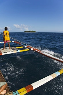 Luzon Prints: Shiphand on catamaran passing small desert island