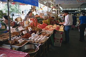 Market Vendor Prints: A shopkeeper pointing at fruit on one of the food stalls