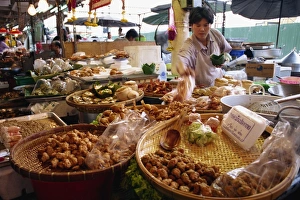 Stall Prints: A shopkeeper puts fish cakes on a tray on a stall in
