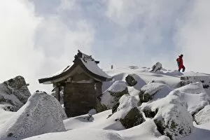 Shrine and climber on snow covered Iwaki San mountain, Aomori prefecture, Japan, Asia