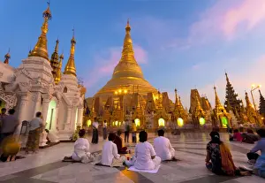 Burma Prints: Shwedagon Paya (Pagoda) at dusk with Buddhist worshippers praying