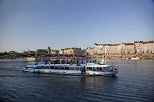 Sightseeing boat on Vltava River with East bank and Jiraskuv Bridge, Prague