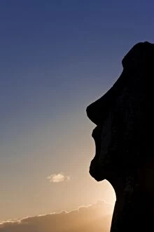 Silhouette of a lone monolithic giant stone Moai statue at Tongariki, Rapa Nui