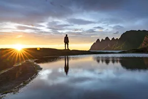 35 39 Years Gallery: Silhouette of man standing on rocks watching the mountain peaks at sunset