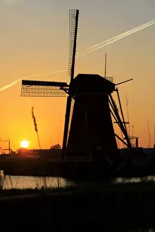The Netherlands Prints: Silhouette of typical windmill framed by the fiery sky at sunset, Kinderdijk, UNESCO