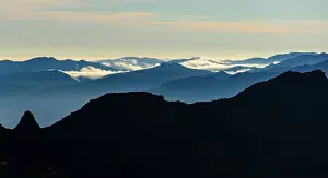 Australasia Prints: Silhouette volcanic landscape in front of blue mountain slopes