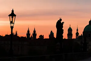 Streetlight Prints: Silhouettes of a statue at Charles Bridge and spires at sunrise