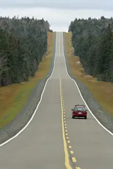 Country Road Prints: A single car on a straight road through the Kouchibouguac National Park