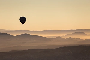 Hazy Prints: Single hot air balloon over a misty dawn sky
