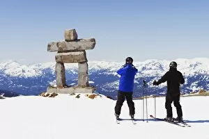 Skiers photographing an Inukshuk statue, Whistler mountain resort, 2010 Winter Olympics venue