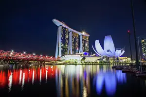 Commercial Prints: Skyline of Singapore Marina Bay at night with Marina Bay Sands and Art Science museum reflecting in a pond after rain