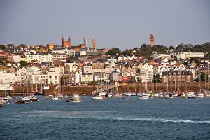 Watercraft Prints: Skyline view of Saint Peter Port showing churches and buildings along the waterfront in Guernsey Channel Islands