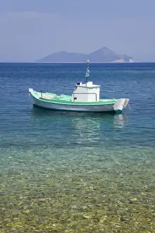 Floating On Water Prints: Small boat anchored offshore, the island of Atokos visible on horizon