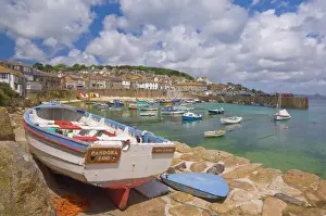Small boat on the quay and small boats in the enclosed harbour at Mousehole
