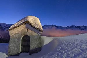 Valtellina Prints: Small chapel covered with snow in the starry winter night, Andossi, Madesimo