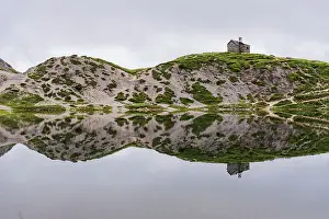 The small church and the reflection of the alpine landscape in the calm water, Olbe lakes, Sappada, Carniche Alps, Udine province, Friuli-Venezia Giulia, Italy, Europe