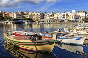 Small fishing boats reflected in Voulismeni Lake, Agios Nikolaos, Lasithi, Crete