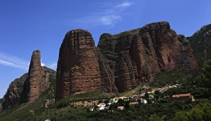 The small village of Riglos below huge conglomerate towers rising over a thousand feet above the plains near Heusca and Jaca, northern Aragon, southern Pyrenees region The small village of Riglos below huge conglomerate towers rising over a thousand feet above the plains near Heusca and Jaca, northern Aragon, southern Pyrenees region