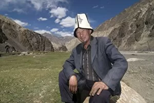 Smiling man with traditional Kyrgyz hats, Madyian, Tajikistan, Central Asia, Asia