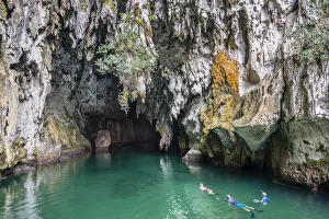 Caves Prints: Snorkellers at the entrance to Tomolo (Goa Keramat) cave, Tomolo, Misool, West Papua