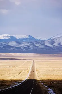 Roads Prints: Snow capped mountains on a straight road of American south west, U