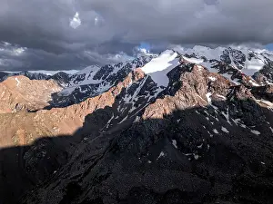 Rugged Terrain Prints: Snow-capped peaks and lush valleys at sunset showcased in a stunning landscape