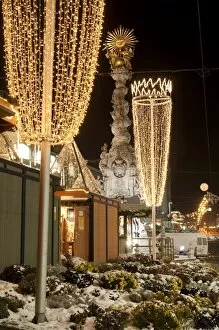 Snow-covered flowers, Christmas decorations and Baroque Trinity Column