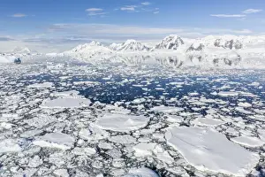 Ice Flow Prints: Snow-covered mountains line the ice floes in Penola Strait, Antarctica, Polar Regions