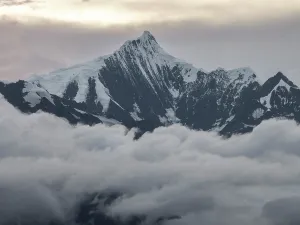 Altitude Prints: Snow-covered peaks rise above clouds in Meili Mountains during evening light in Yunnan