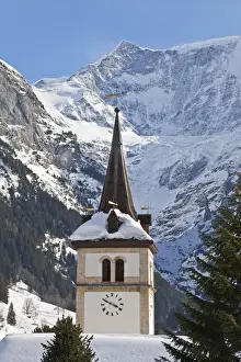 Snow and ice covered mountains above the village church in Grindelwald