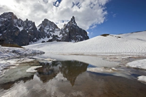 Snow is thawing leaving some puddles at the foot of the Pale di San Martino by San Martino di Castrozza, Dolomites, Trentino, Italy, Europe Snow is thawing leaving some puddles at the foot of the Pale di San Martino by San Martino di Castrozza, Dolomites, Trentino, Italy, Europe