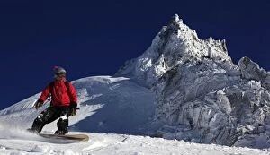 Images Dated 18th January 2010: A snowboarder riding powder snow off the top of the famous Grand Montets ski area
