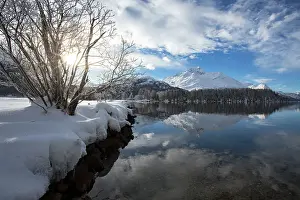Engadine Prints: Snowcapped mountains reflected in the icy Lake Sils during a cold winter