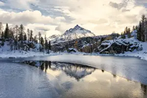 Sondrio Prints: Snowy peak of Sasso Moro reflected in the frozen lake MufulA¨, Malenco Valley