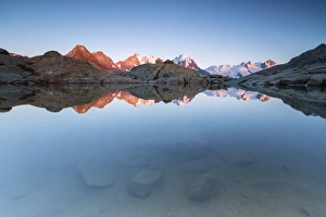 Alpen Glow Prints: Snowy peaks reflected in the alpine lake at sunset, Fuorcla, Surlej, St