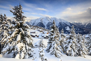 Snowy woods and mountain huts framed by the winter sunset, Bettmeralp, district of Raron