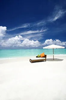 Sofa and parasol on tropical beach, The Maldives, Indian Ocean, Asia
