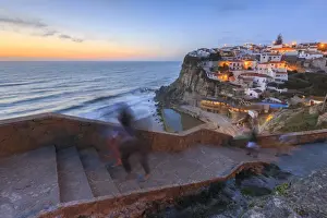 The soft colors of twilight frame the ocean and the village of Azenhas do Mar, Sintra