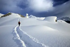 Track Prints: A solitary hiker leaving the little village at the Scima Alp covered in snow