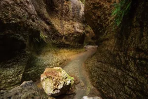 Canyon Prints: Solitary rock in shallow stream at Barranco de Luna with sandstone walls in Granada