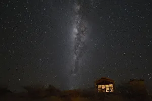 Spiral Galaxy Prints: South hemisphere Milky Way and a small illuminated hut, Namibia, Africa