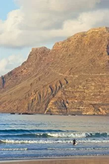 Spectacular 600m volcanic cliffs of the Risco de Famara rising over Lanzarotes finest surf beach at Famara in the north