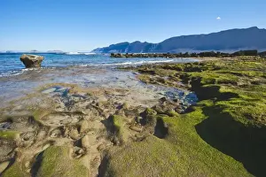 Spectacular 600m volcanic cliffs of the Risco de Famara and Graciosa Island backdrop to the rocky southern shore of the bay at Famara in the north west, Lanzarote, Canary Islands, Spain, Atlantic