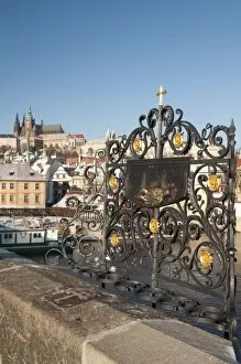 St. John of Nepomuk (Jan Nepomucky) shrine with cross at Charles Bridge with snow-covered Prague Castle