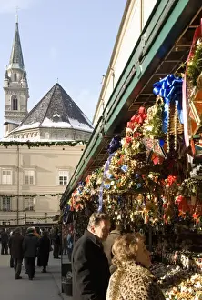 Stalls Prints: Stall selling Christmas decorations with towers of Franziskanerkirche churchbehind