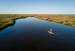 Rippled Gallery: Stand up paddle boarder paddles through a Chesapeake Bay salt marsh near Hampton